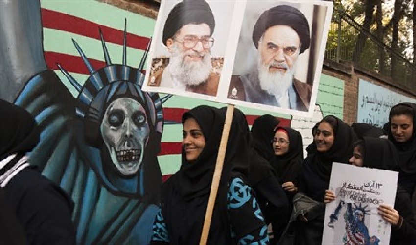 Iranian Protesting outside the site of the former US embassy which included their intents against three main enemies of the moment by a display which also involved the public burning of Israeli, American and British flags.